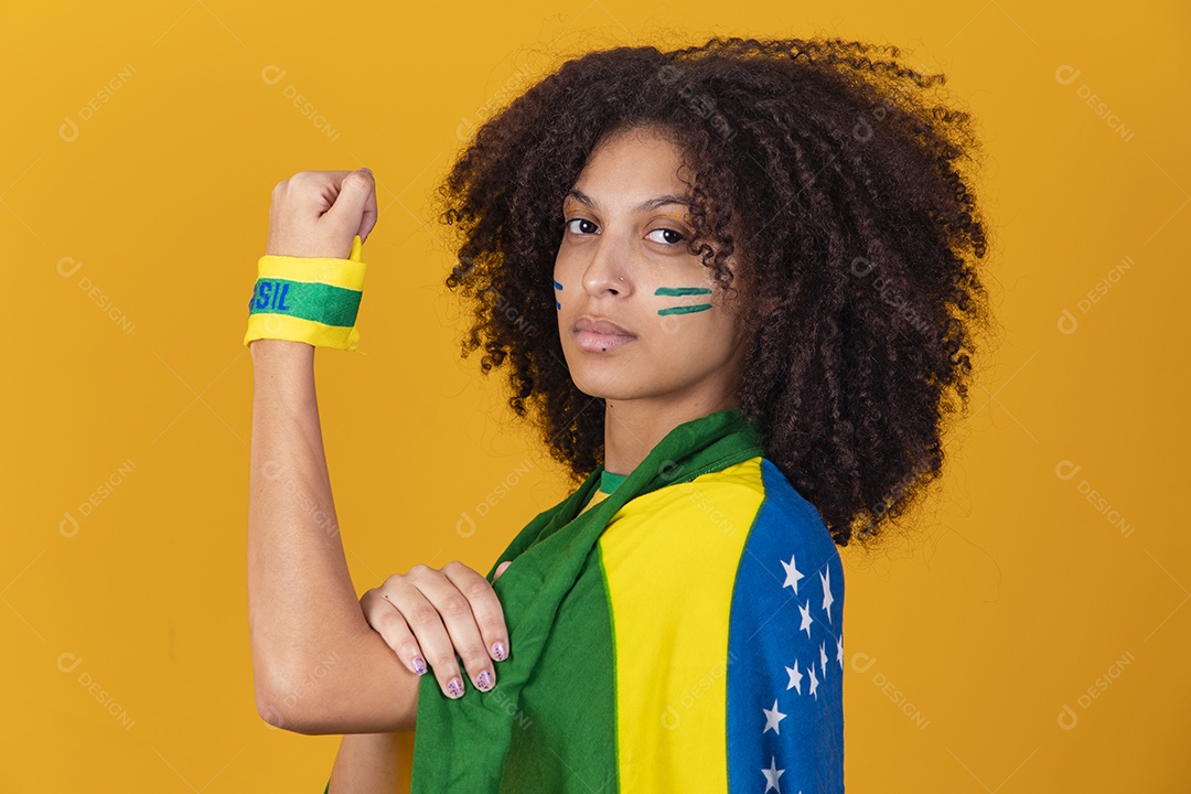 Mulher afro-brasileira vestindo camiseta do Brasil e bandeira nacional