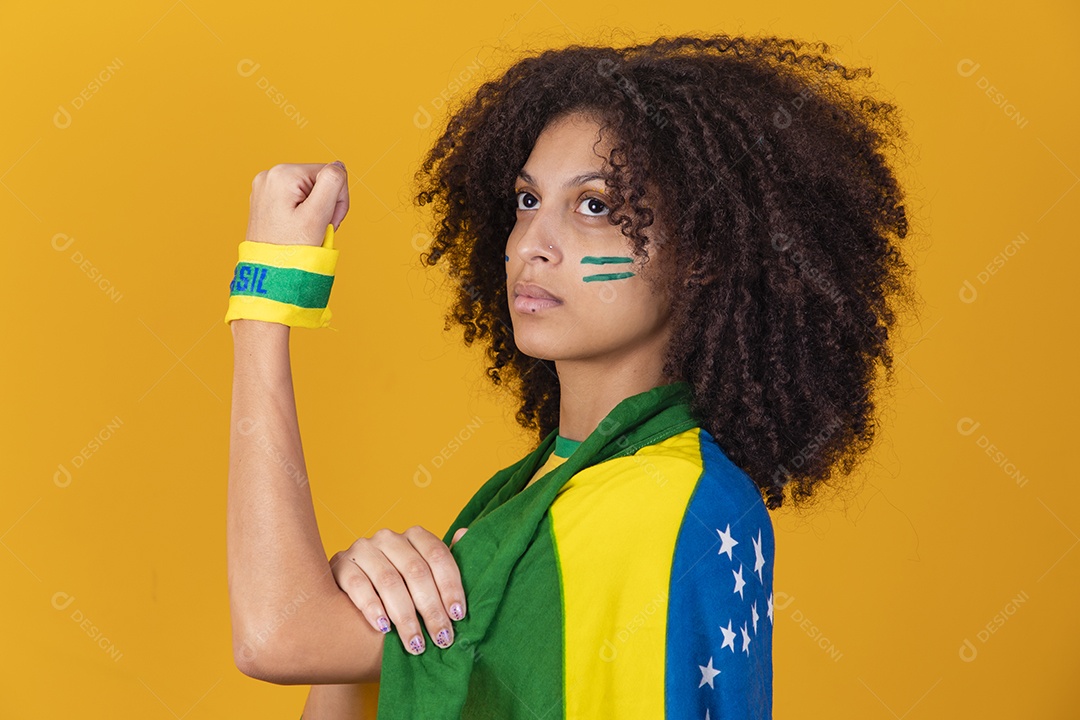 Mulher afro-brasileira vestindo camiseta do Brasil e bandeira nacional