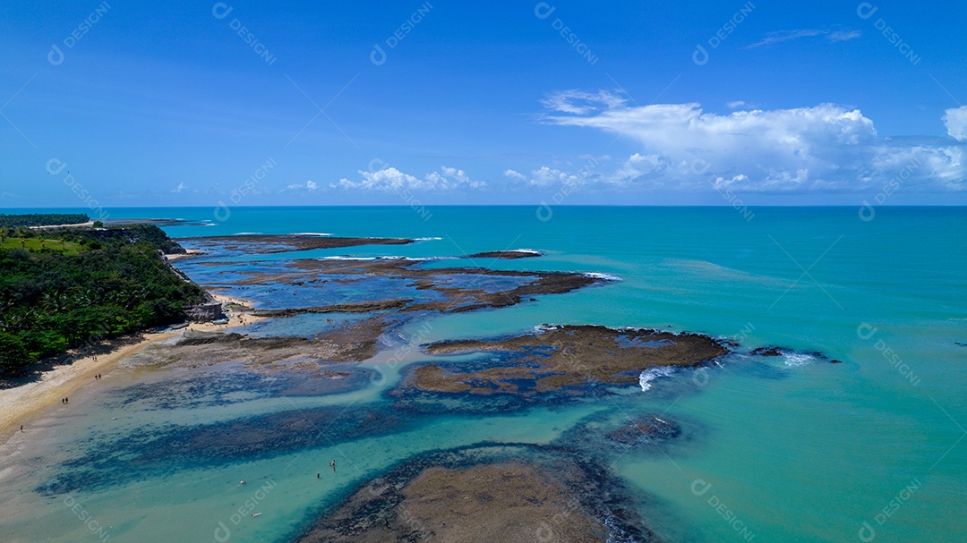 Vista aérea da Praia do Espelho, Porto Seguro, Bahia, Brasil. Piscinas naturais no mar, falésias e águas esverdeadas.