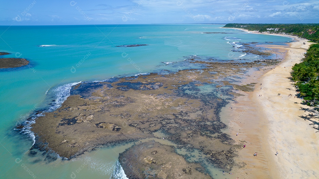 Vista aérea da Praia do Espelho, Porto Seguro, Bahia, Brasil. Piscinas naturais no mar, falésias e águas esverdeadas.