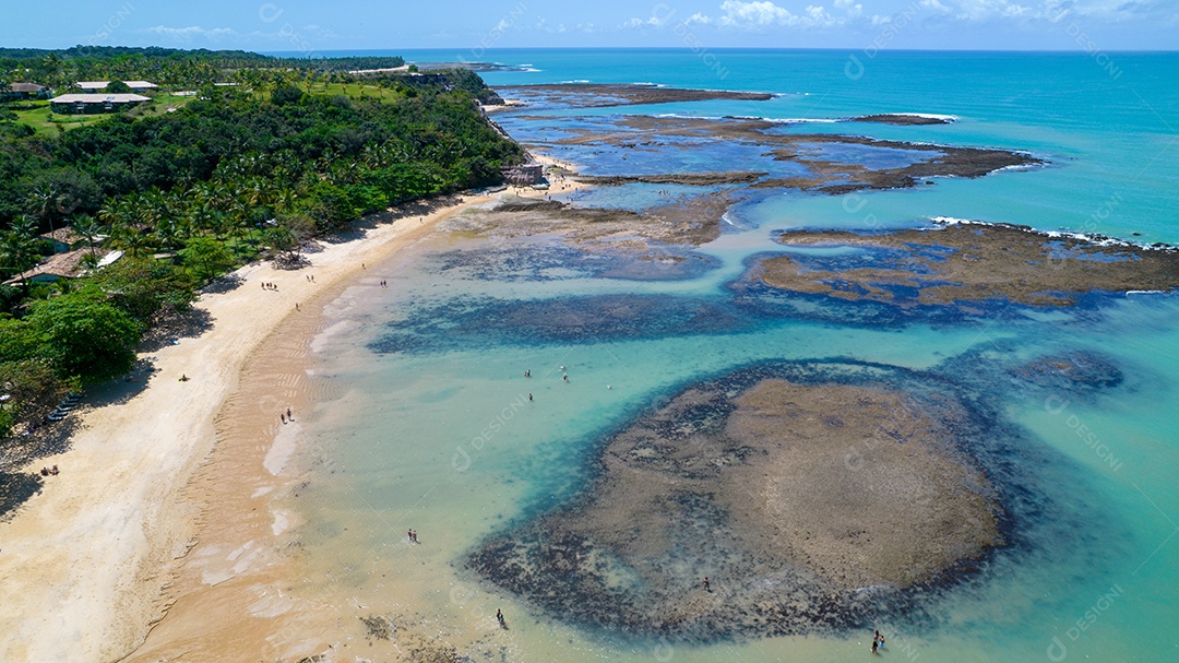 Vista aérea da Praia do Espelho, Porto Seguro, Bahia, Brasil. Piscinas naturais no mar, falésias e águas esverdeadas.