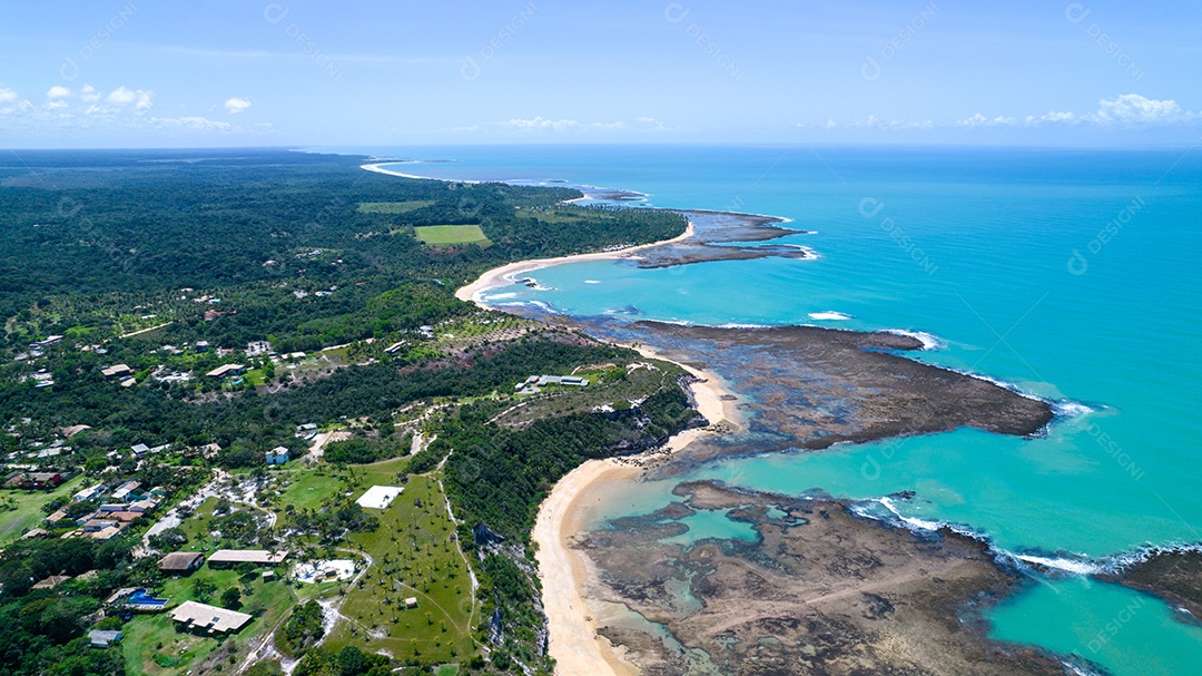 Vista aérea da Praia do Espelho, Porto Seguro, Bahia, Brasil. Piscinas naturais no mar, falésias e águas esverdeadas.