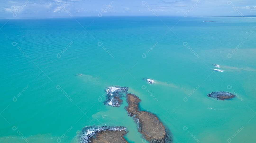 Vista aérea da Praia do Espelho, Porto Seguro, Bahia, Brasil. Piscinas naturais no mar, falésias e águas esverdeadas.