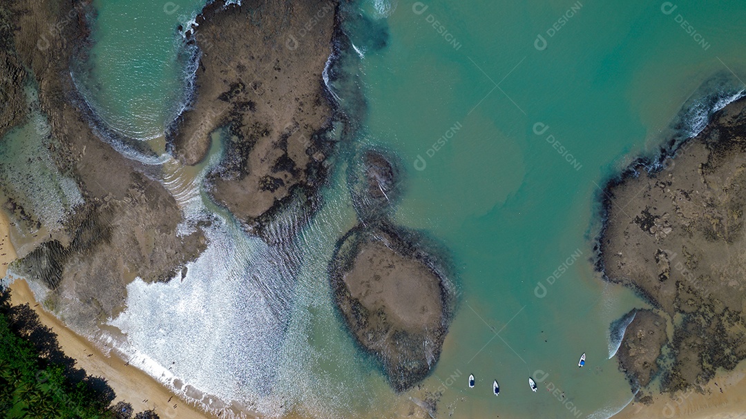 Vista aérea da Praia do Espelho, Porto Seguro, Bahia, Brasil. Piscinas naturais no mar, falésias e águas esverdeadas.