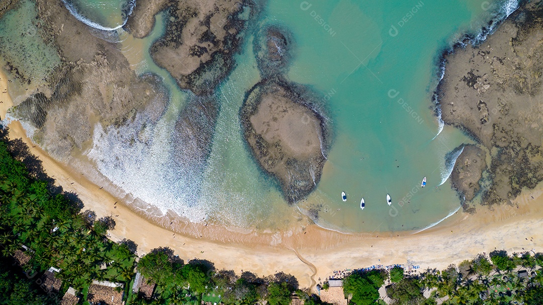 Vista aérea da Praia do Espelho, Porto Seguro, Bahia, Brasil. Piscinas naturais no mar, falésias e águas esverdeadas.