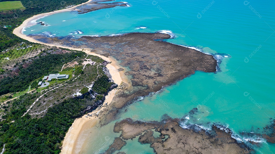 Vista aérea da Praia do Espelho, Porto Seguro, Bahia, Brasil. Piscinas naturais no mar, falésias e águas esverdeadas.