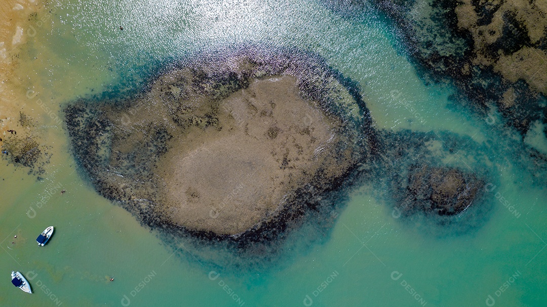 Vista aérea da Praia do Espelho, Porto Seguro, Bahia, Brasil. Piscinas naturais no mar, falésias e águas esverdeadas.