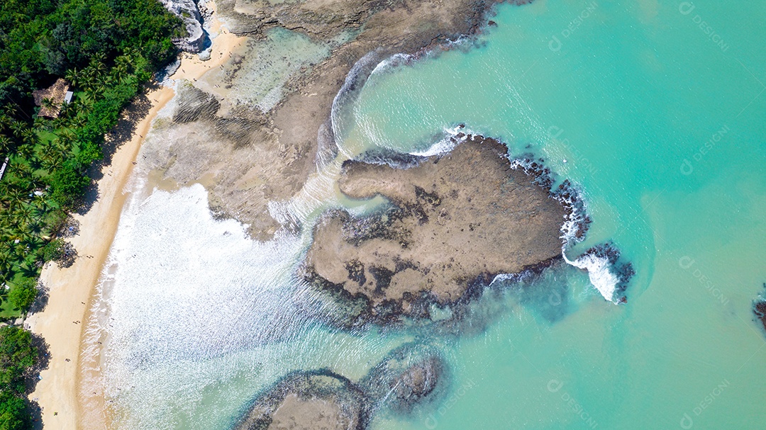 Vista aérea da Praia do Espelho, Porto Seguro, Bahia, Brasil. Piscinas naturais no mar, falésias e águas esverdeadas.
