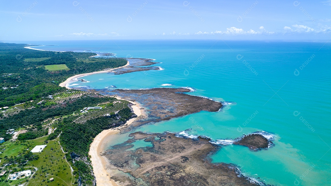 Vista aérea da Praia do Espelho, Porto Seguro, Bahia, Brasil. Piscinas naturais no mar, falésias e águas esverdeadas.