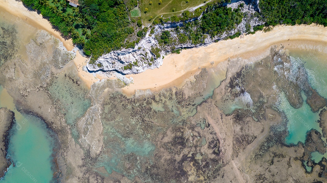 Vista aérea da Praia do Espelho, Porto Seguro, Bahia, Brasil. Piscinas naturais no mar, falésias e águas esverdeadas.