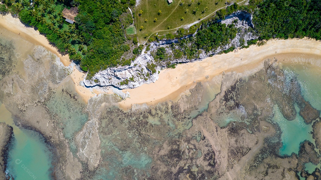 Vista aérea da Praia do Espelho, Porto Seguro, Bahia, Brasil. Piscinas naturais no mar, falésias e águas esverdeadas.