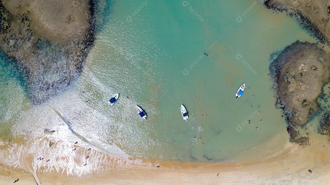 Vista aérea da Praia do Espelho, Porto Seguro, Bahia, Brasil. Piscinas naturais no mar, falésias e águas esverdeadas.