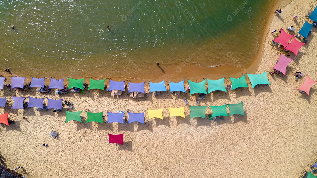 Vista aérea da praia de Caraiva, Porto Seguro, Bahia, Brasil. Barracas de praia coloridas, mar e rio.