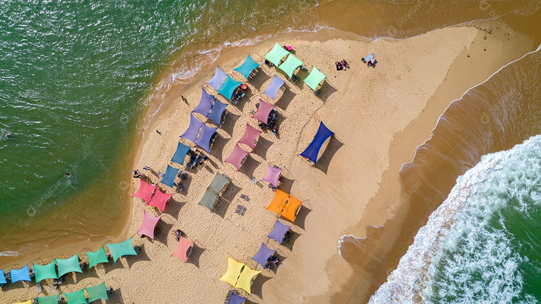 Vista aérea da praia de Caraiva, Porto Seguro, Bahia, Brasil. Barracas de praia coloridas, mar e rio.