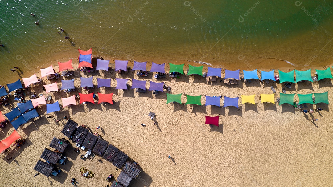 Vista aérea da praia de Caraiva, Porto Seguro, Bahia, Brasil. Barracas de praia coloridas, mar e rio.