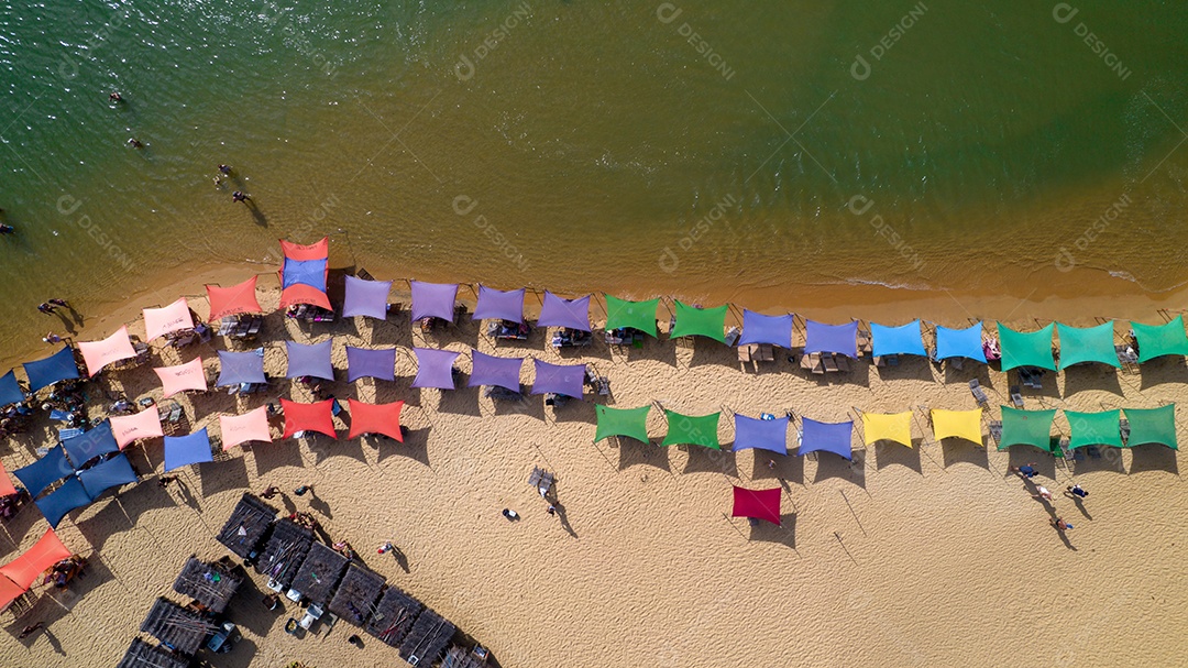 Vista aérea da praia de Caraiva, Porto Seguro, Bahia, Brasil. Barracas de praia coloridas, mar e rio.