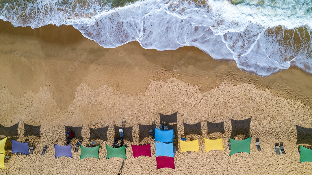 Vista aérea da praia de Caraiva, Porto Seguro, Bahia, Brasil. Barracas de praia coloridas, mar e rio.