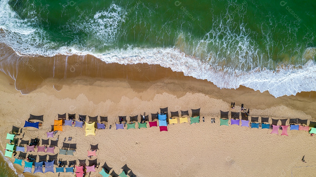 Vista aérea da praia de Caraiva, Porto Seguro, Bahia, Brasil. Barracas de praia coloridas, mar e rio.