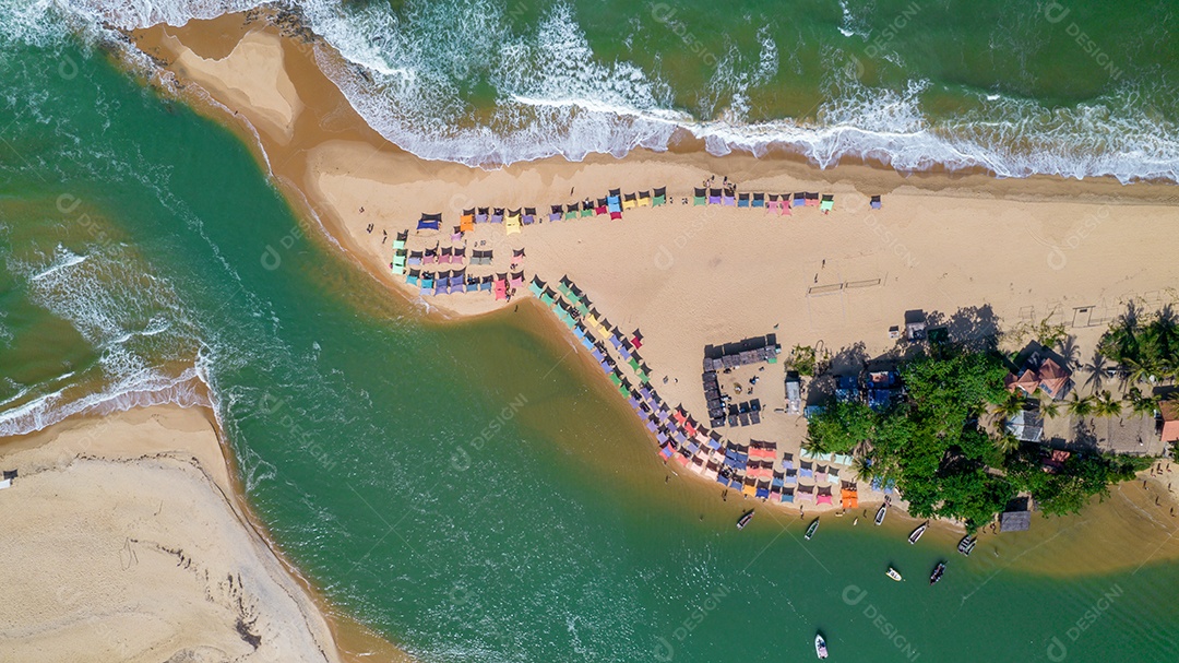 Vista aérea da praia de Caraiva, Porto Seguro, Bahia, Brasil. Barracas de praia coloridas, mar e rio.