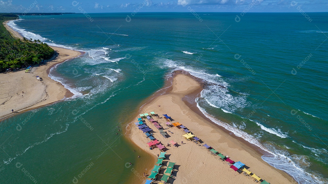 Vista aérea da praia de Caraiva, Porto Seguro, Bahia, Brasil. Barracas de praia coloridas, mar e rio.