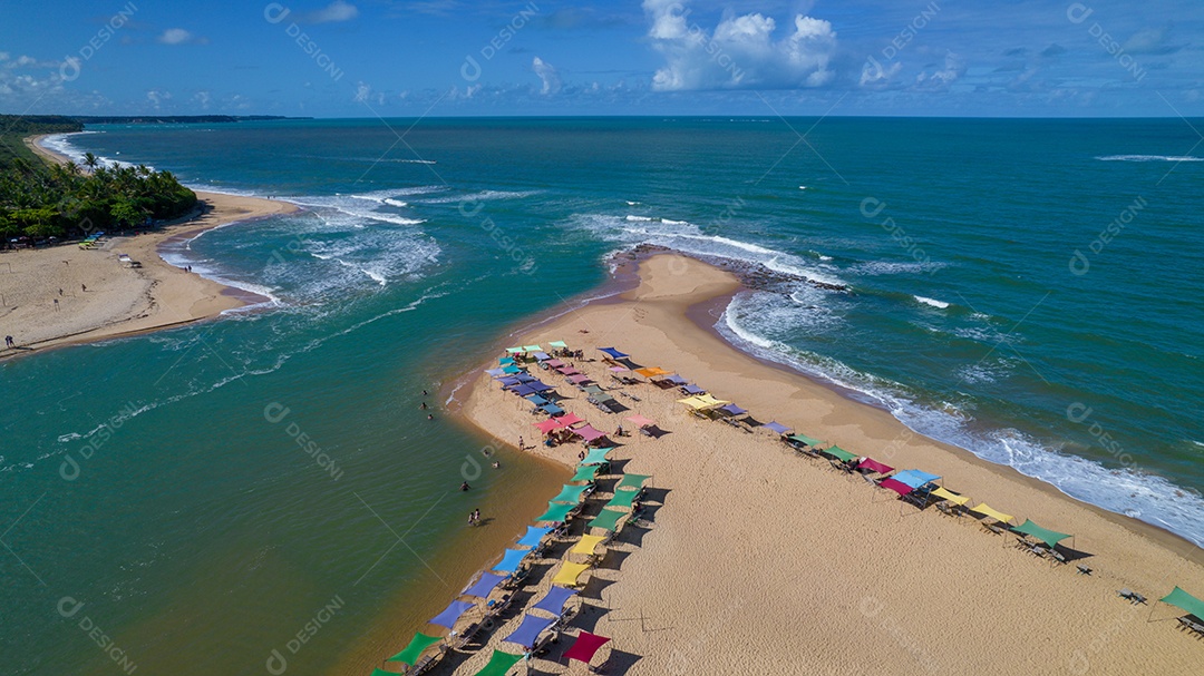 Vista aérea da praia de Caraiva, Porto Seguro, Bahia, Brasil. Barracas de praia coloridas, mar e rio.