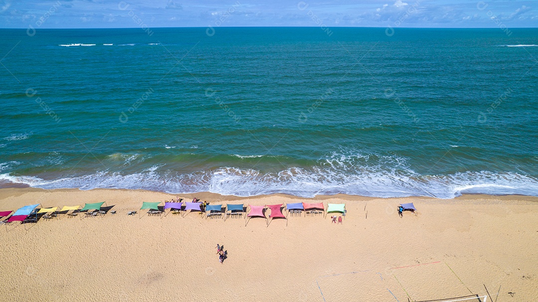 Vista aérea da praia de Caraiva, Porto Seguro, Bahia, Brasil. Barracas de praia coloridas, mar e rio.