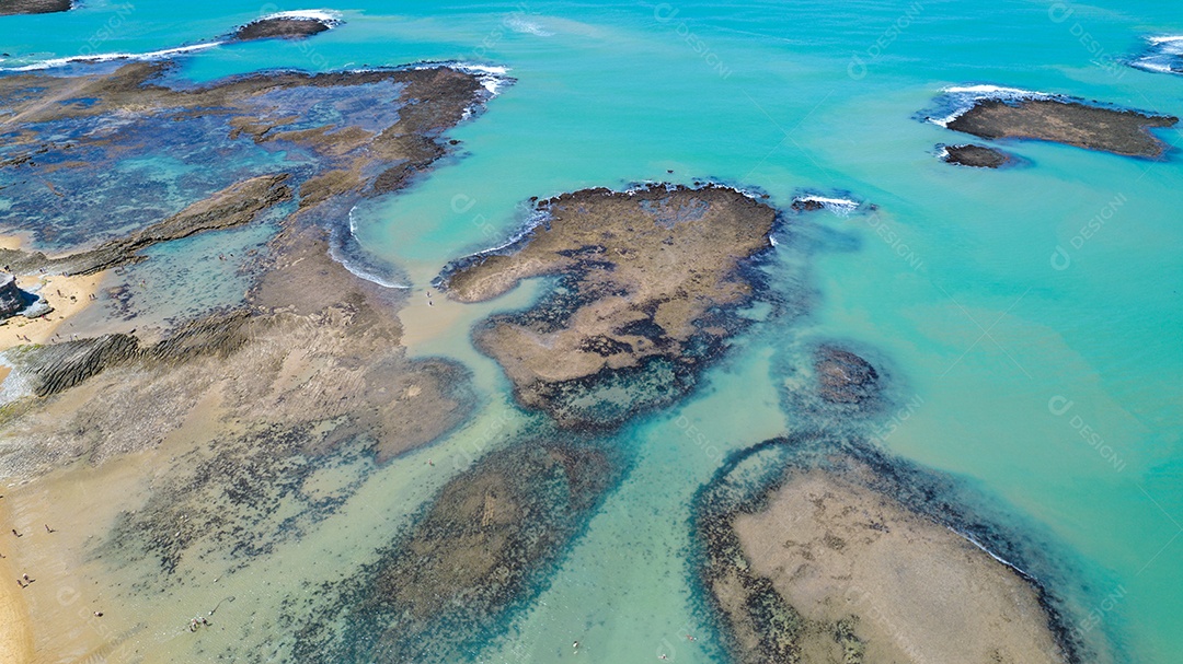 Vista aérea da Praia do Espelho, Porto Seguro, Bahia, Brasil. Piscinas naturais no mar, falésias e águas esverdeadas.