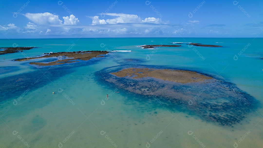 Vista aérea da Praia do Espelho, Porto Seguro, Bahia, Brasil. Piscinas naturais no mar, falésias e águas esverdeadas.