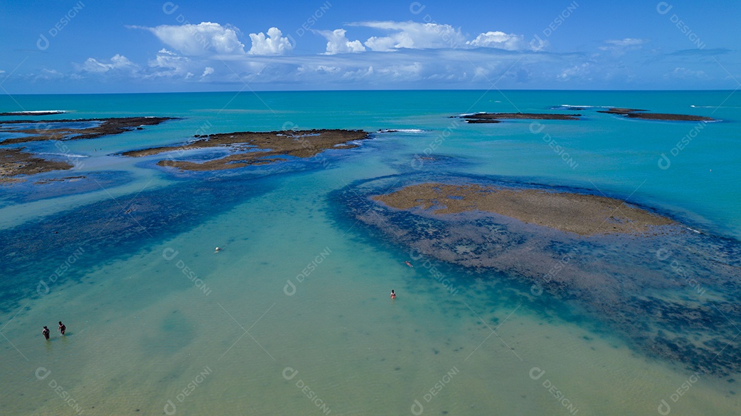 Vista aérea da Praia do Espelho, Porto Seguro, Bahia, Brasil. Piscinas naturais no mar, falésias e águas esverdeadas.