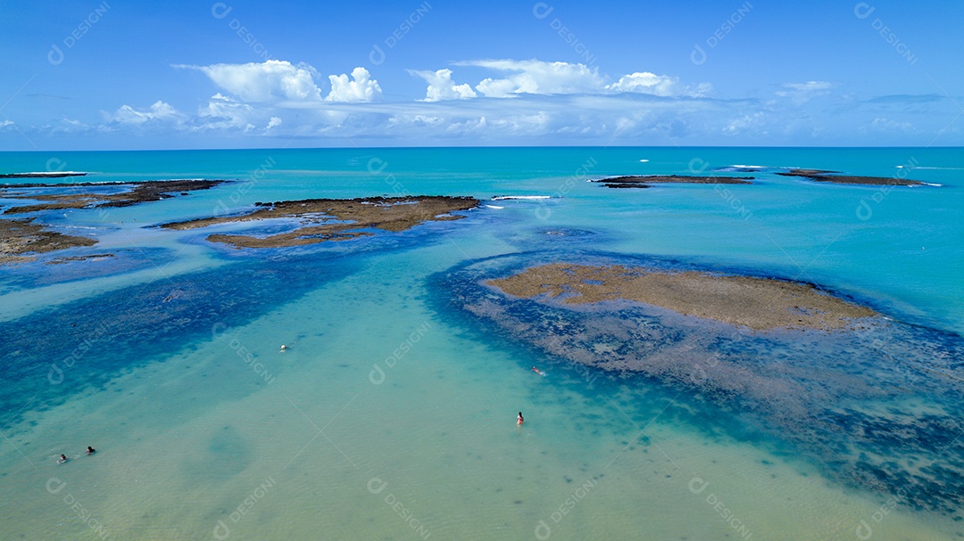 Vista aérea da Praia do Espelho, Porto Seguro, Bahia, Brasil. Piscinas naturais no mar, falésias e águas esverdeadas.