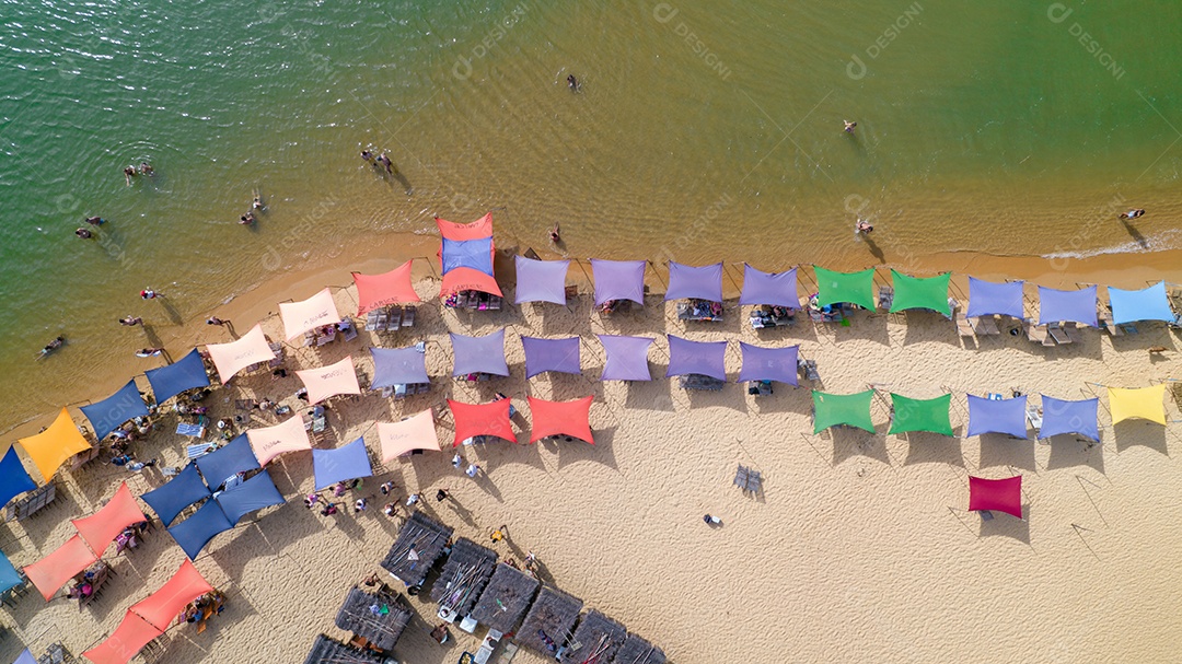 Vista aérea da praia de Caraiva, Porto Seguro, Bahia, Brasil. Barracas de praia coloridas, mar e rio.