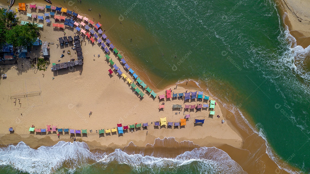 Vista aérea da praia de Caraiva, Porto Seguro, Bahia, Brasil. Barracas de praia coloridas, mar e rio.