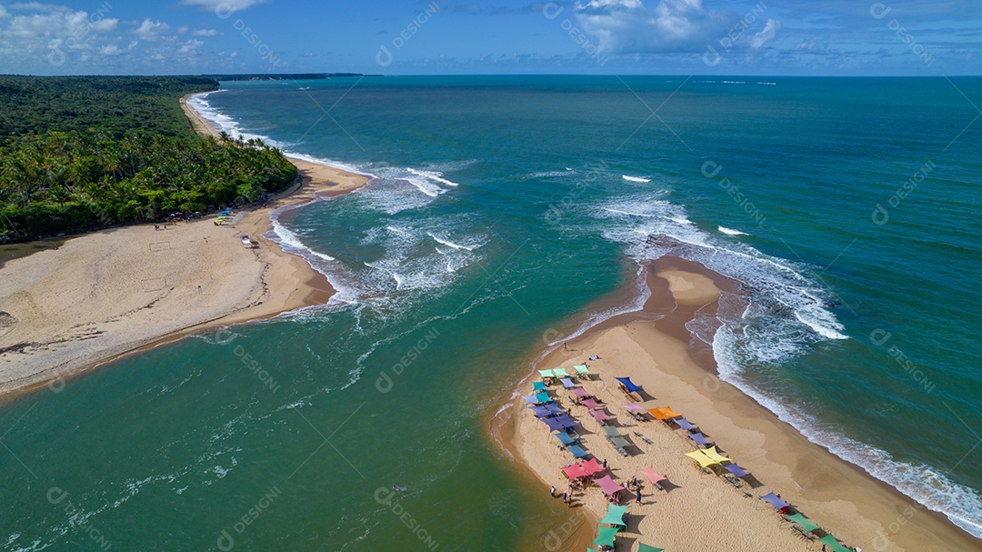 Vista aérea da praia de Caraiva, Porto Seguro, Bahia, Brasil. Barracas de praia coloridas, mar e rio.