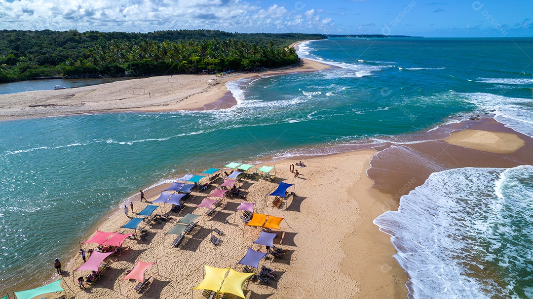 Vista aérea da praia de Caraiva, Porto Seguro, Bahia, Brasil. Barracas de praia coloridas, mar e rio.