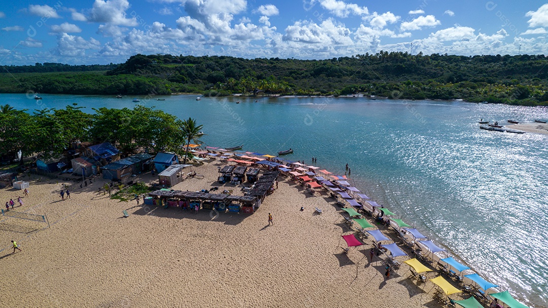 Vista aérea da praia de Caraiva, Porto Seguro, Bahia, Brasil. Barracas de praia coloridas, mar e rio.