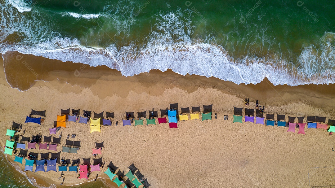 Vista aérea da praia de Caraiva, Porto Seguro, Bahia, Brasil. Barracas de praia coloridas, mar e rio.