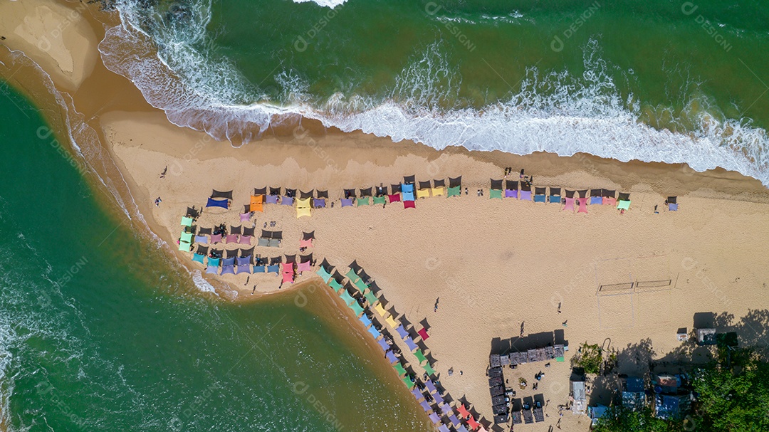 Vista aérea da praia de Caraiva, Porto Seguro, Bahia, Brasil. Barracas de praia coloridas, mar e rio.