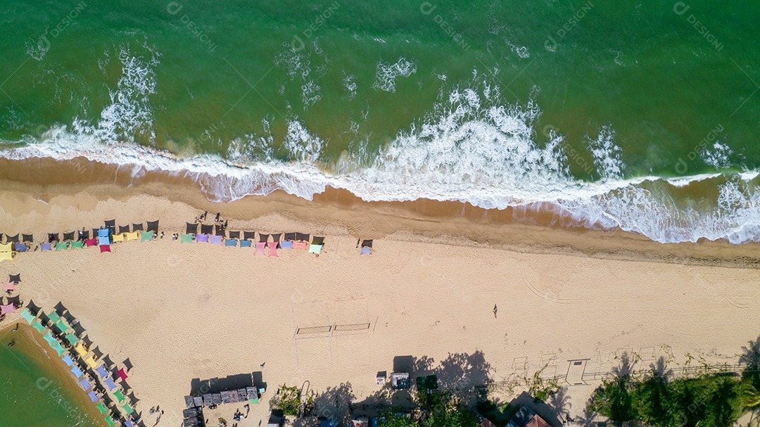 Vista aérea da praia de Caraiva, Porto Seguro, Bahia, Brasil. Barracas de praia coloridas, mar e rio.