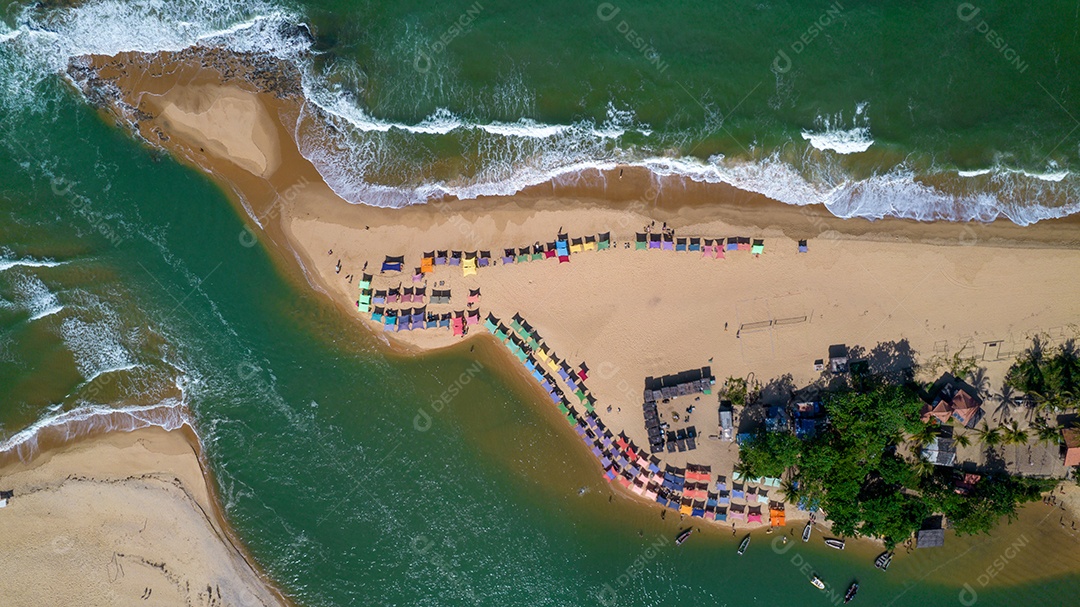 Vista aérea da praia de Caraiva, Porto Seguro, Bahia, Brasil. Barracas de praia coloridas, mar e rio.