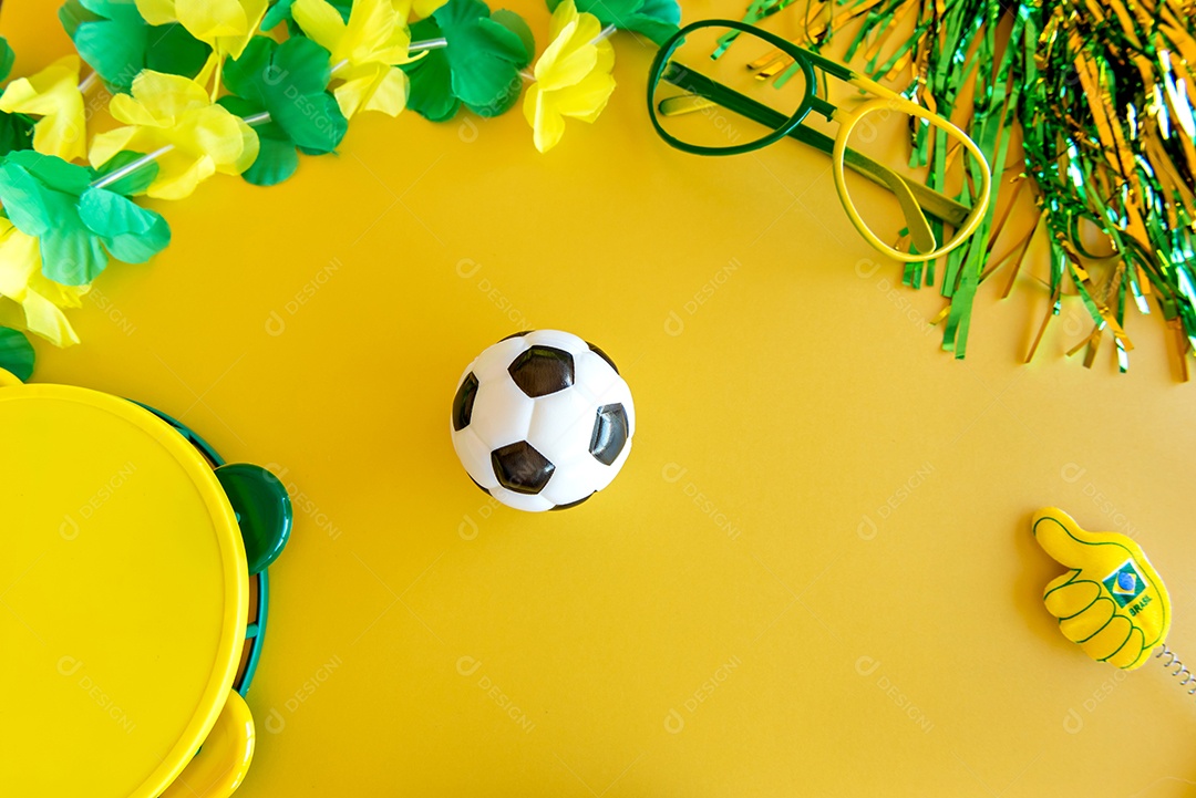 bola de futebol e alguns itens de fãs brasileiros em fundo amarelo