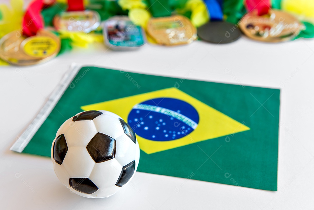 bola de futebol, bandeira brasileira e medalhas em fundo branco