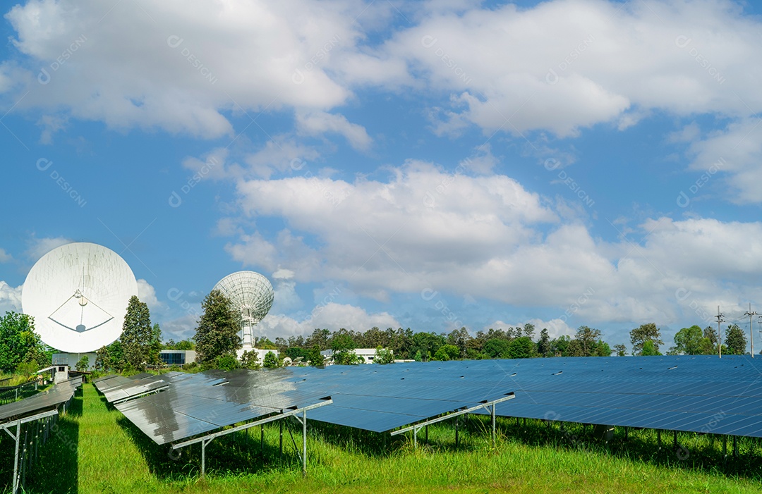 Fazenda solar e campo verde com céu azul. Grande antena parabólica