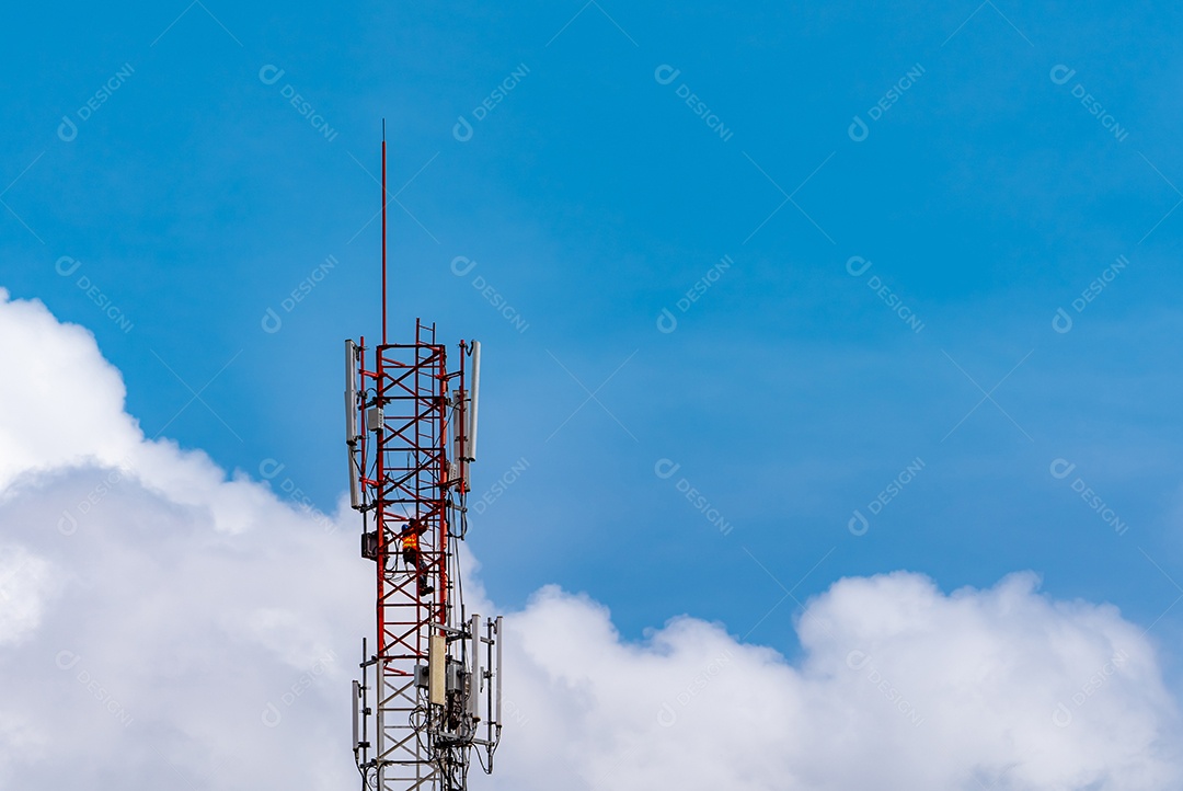 Torre de telecomunicações com céu azul e nuvens brancas.