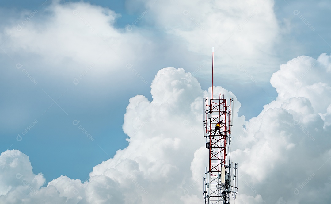Torre de telecomunicações com céu azul e nuvens brancas.