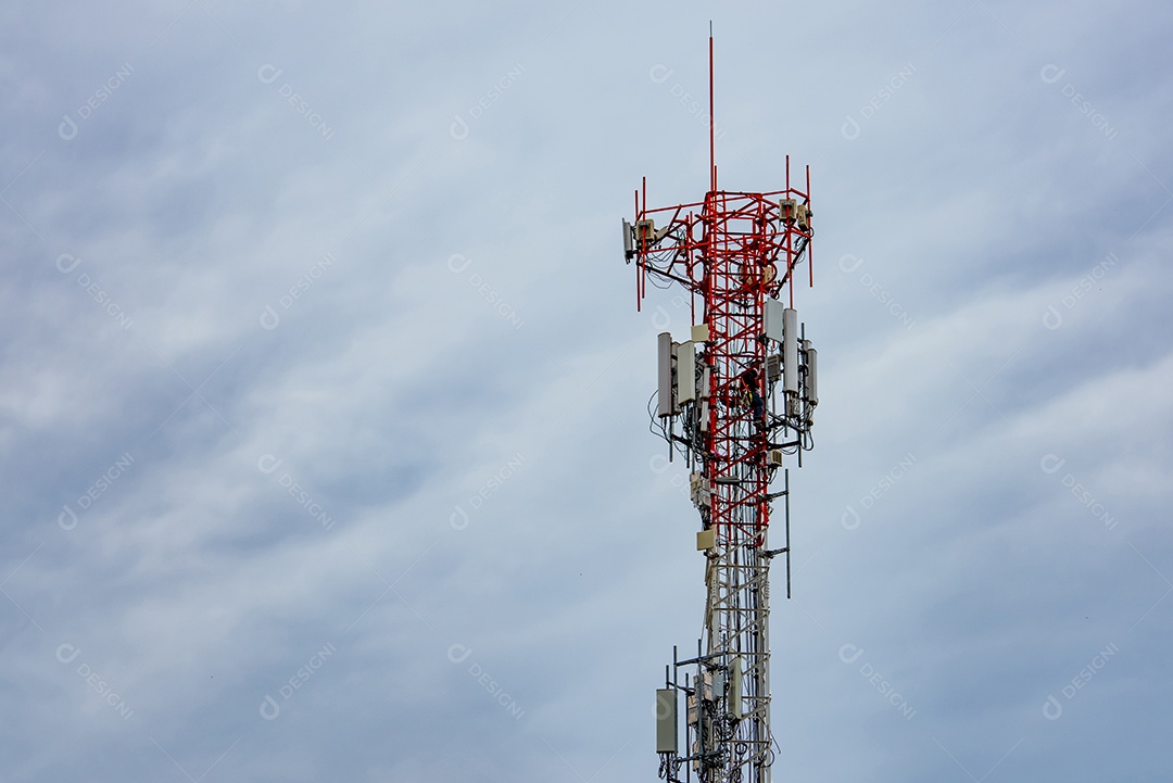 Torre de telecomunicações com céu azul e nuvens brancas.