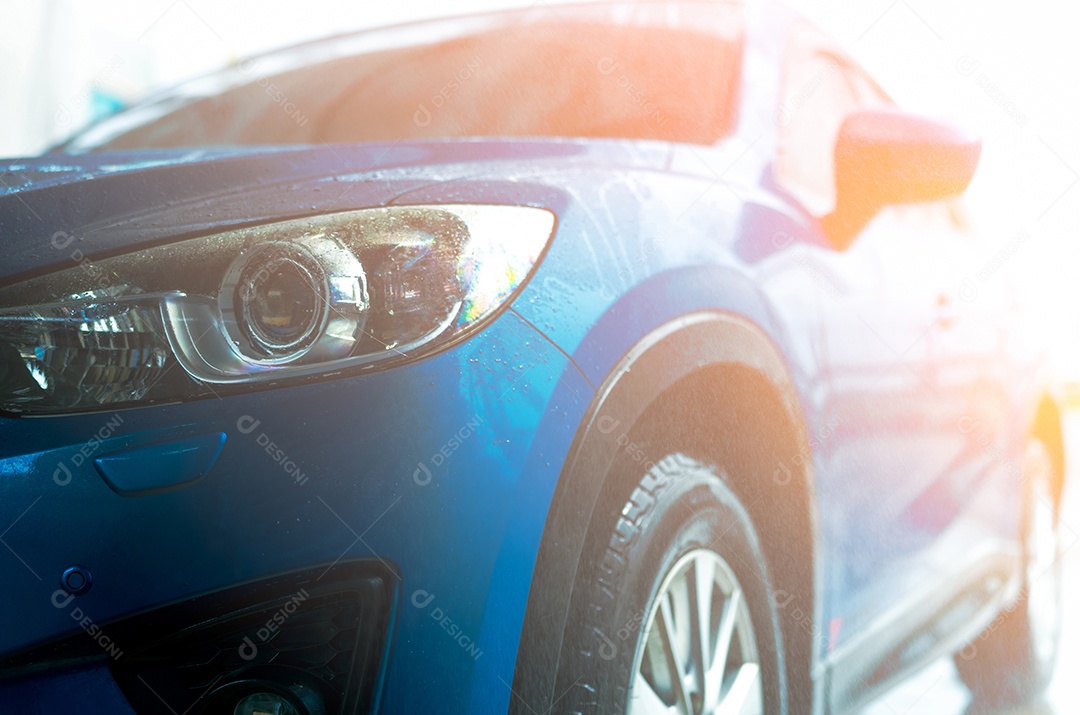 O carro azul está lavando com água. Negócio de auto cuidado.