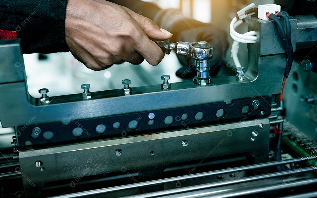 Mão de técnico mecânico consertando máquinas industriais na fábrica.