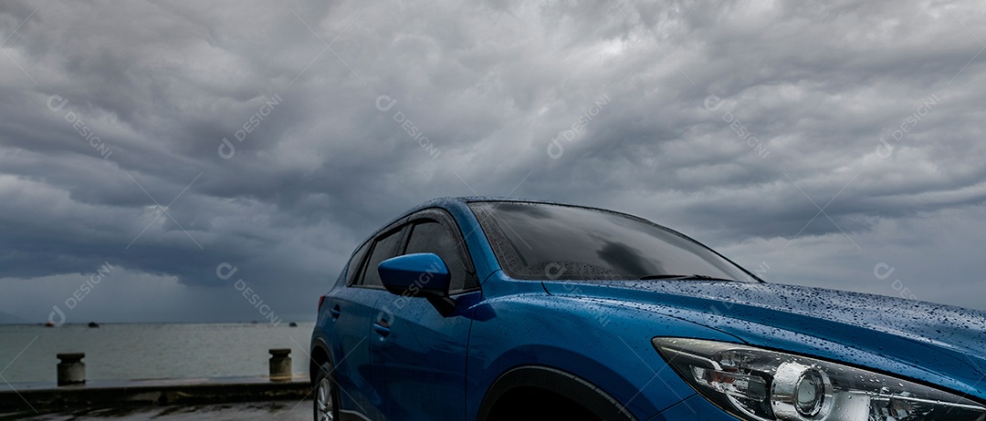 Carro SUV azul com gotas de água estacionados no estacionamento perto da praia do mar