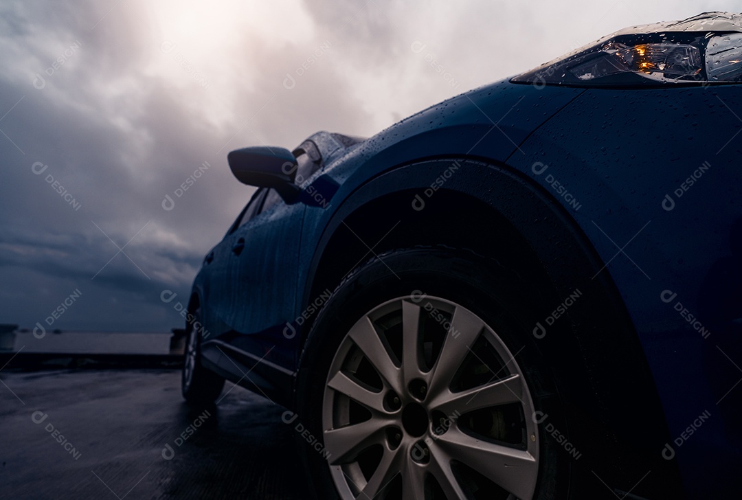 Novo carro SUV azul de luxo estacionado na estrada de concreto ao lado da praia
