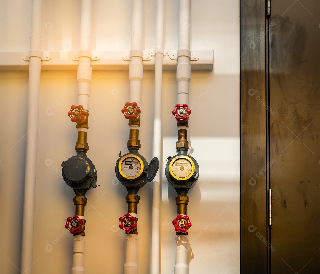 Único medidor de água e válvulas vermelhas na parede de concreto branca da casa